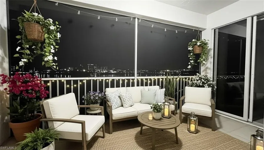 Balcony at night featuring an outdoor living space and a sunroom
