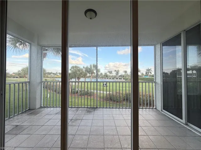 Unfurnished sunroom with tile patterned floors and a water view
