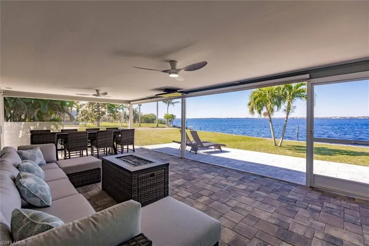 View of patio / terrace featuring an outdoor living space with a fire pit, a water view, and ceiling fan
