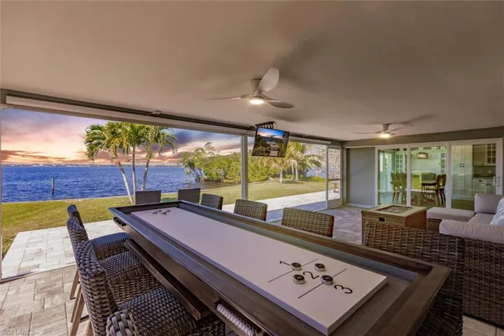 Patio terrace at dusk featuring an outdoor hangout area, a lawn, and a ceiling fan
