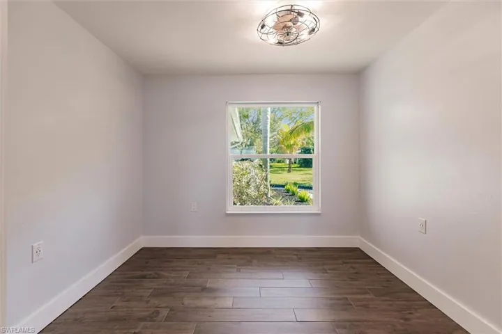 Empty room with dark wood-style floors and baseboards