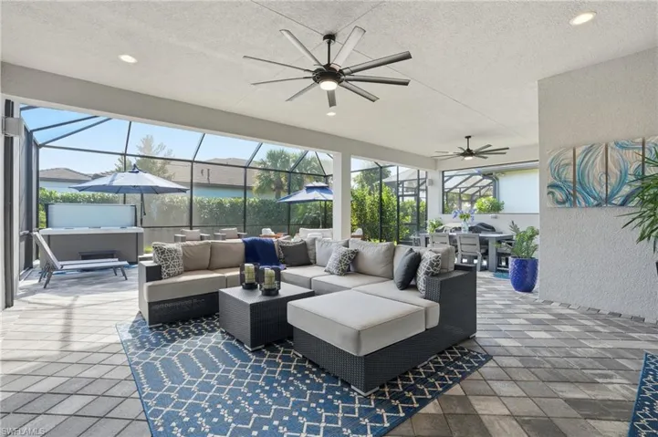 View of patio / terrace with outdoor dining area, ceiling fan, a sunroom, and glass enclosure