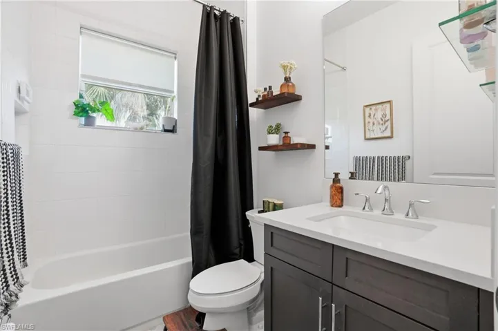 Full bathroom featuring shower / bath combination with curtain and vanity