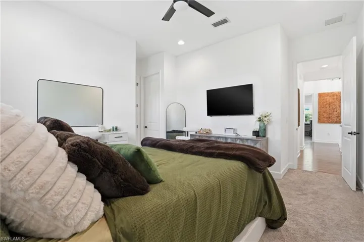 Bedroom featuring light colored carpet, recessed lighting, and ceiling fan
