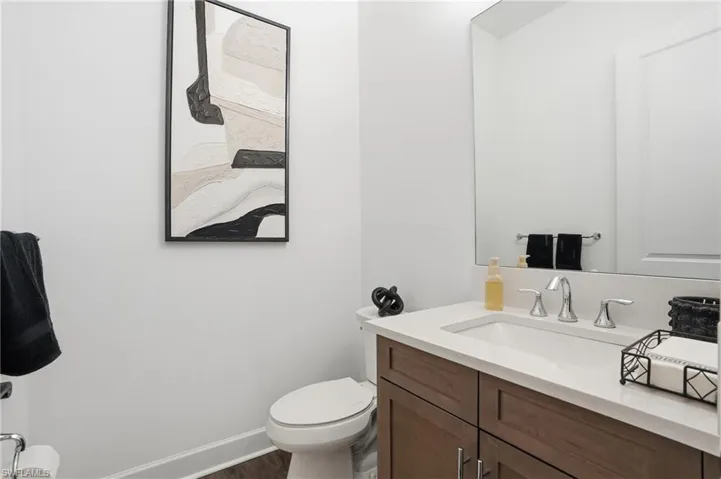 Half bathroom with vanity and dark wood-type flooring