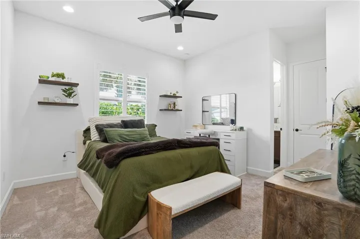 Bedroom featuring light carpet, ceiling fan, recessed lighting, and connected bathroom