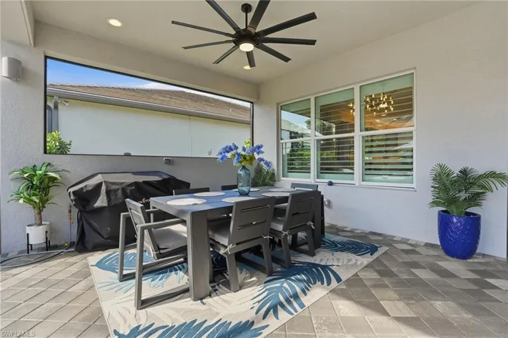 View of patio with outdoor dining area, a ceiling fan, and area for grilling