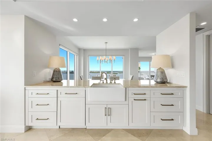 Enjoy sweeping water views from the kitchen, where updated appliances and timeless white cabinetry create a bright and refined culinary space.