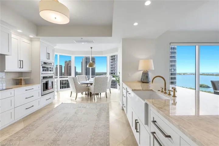 Beautifully updated kitchen features white cabinetry, generous counter space, and expansive views.
