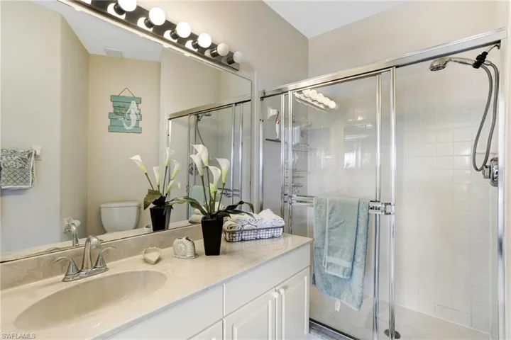 Masterbathroom featuring an enclosed shower, vanity, and toilet