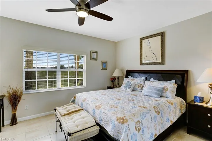 Tiled masterbedroom featuring ceiling fan