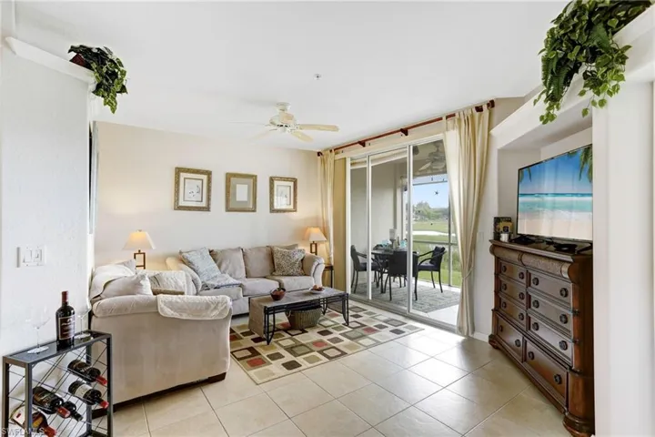Living room with light tile patterned floors and ceiling fan