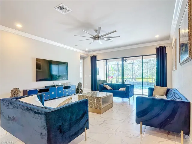 Living room featuring ornamental molding and ceiling fan