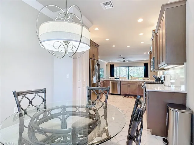 Dining area with sink and ceiling fan with notable chandelier