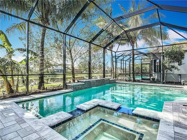 View of pool with an in ground hot tub and a lanai