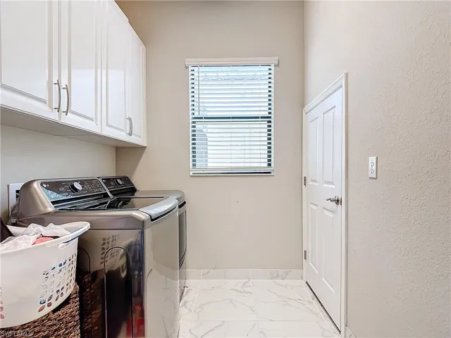 Washroom with cabinets and washer and dryer