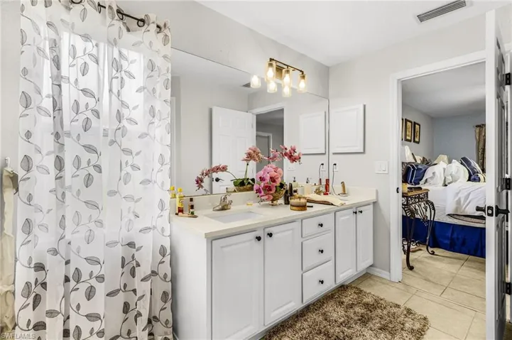 Bathroom with double vanity, ensuite bath, and a shower with shower curtain