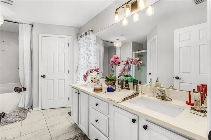 Bathroom featuring double vanity and light tile patterned floors