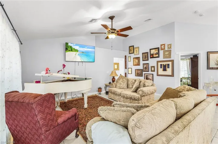 Living room featuring ceiling fan and lofted ceiling