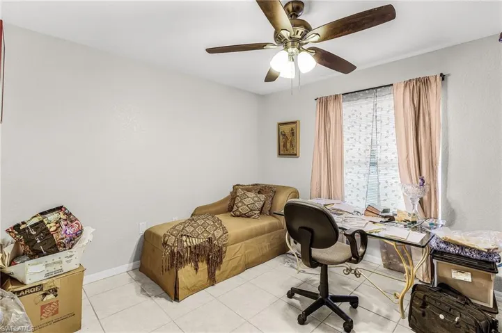 Tiled office Bedroom 4 with ceiling fan and baseboards