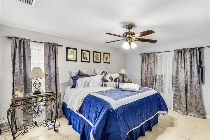 Bedroom with a ceiling fan and light tile patterned flooring