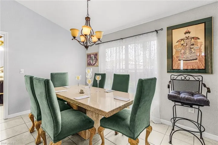 Dining space with suspended lighting and light tile patterned floors