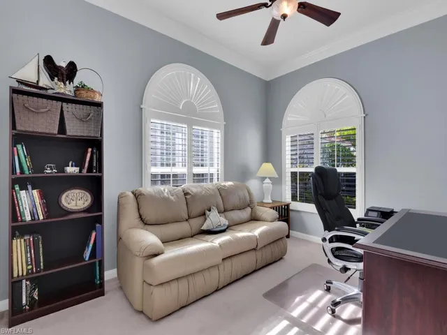 Carpeted office space featuring a wealth of natural light and crown molding