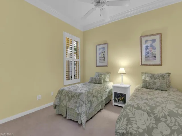 Bedroom with ceiling fan, crown molding, and carpet