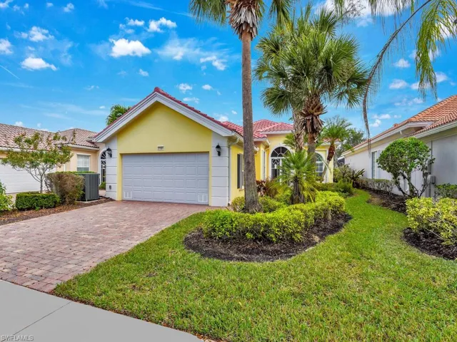 View of front of property featuring a garage, central air condition unit, and a front lawn