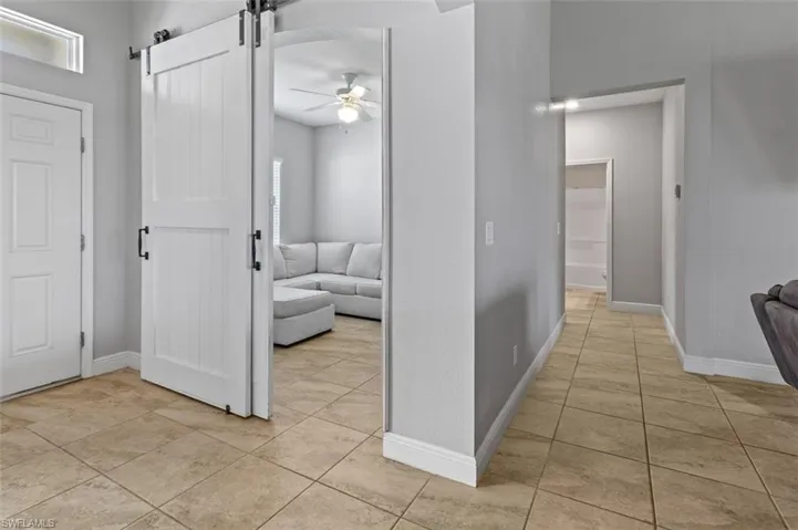 Hall with a barn door and light tile floors