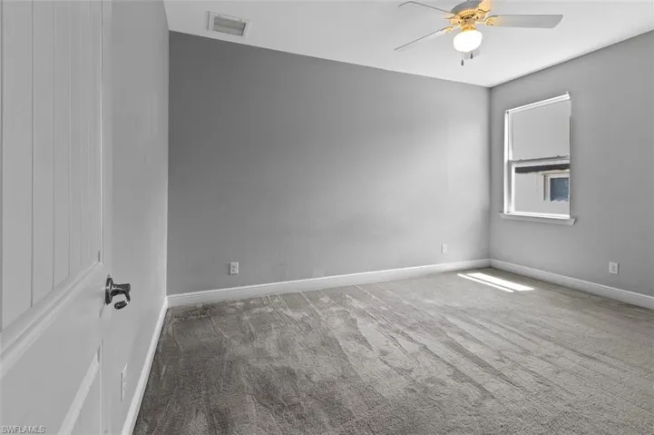 Carpeted spare room with ceiling fan