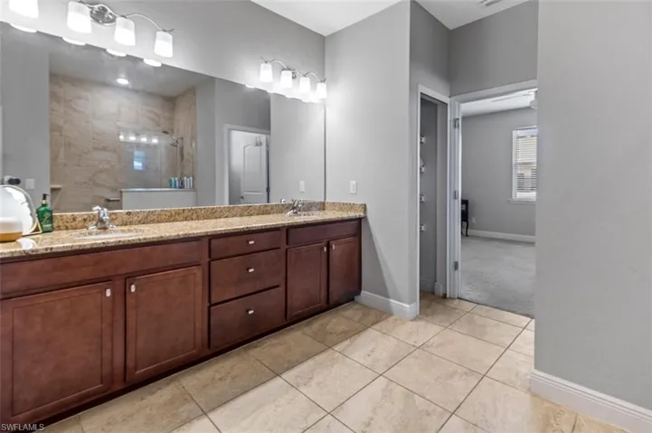 Bathroom with dual bowl vanity and tile flooring