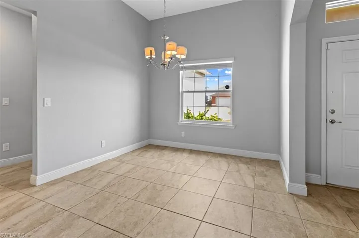 Unfurnished room featuring an inviting chandelier and light tile floors
