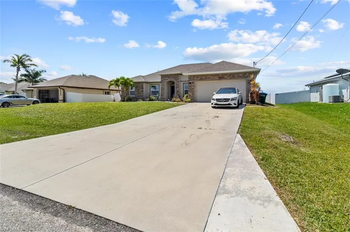 Ranch-style home with a front lawn and a garage