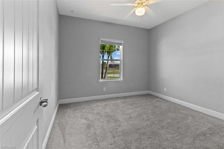 Carpeted empty room with ceiling fan