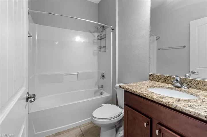 Full bathroom with tile flooring, vanity, toilet, and shower / bathtub combination