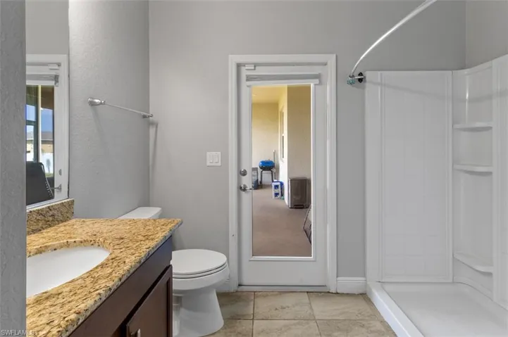 Bathroom featuring tile floors, a shower, toilet, and vanity