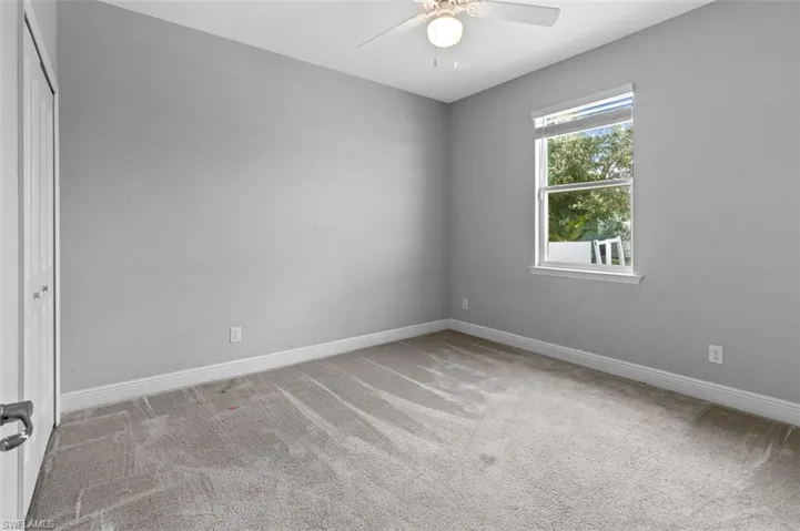 Spare room with ceiling fan and carpet flooring