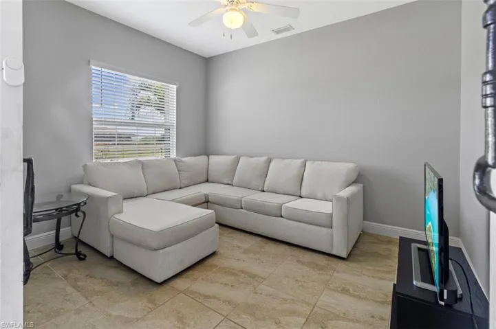 Living room featuring ceiling fan and light tile floors