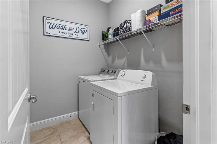 Washroom featuring washer and clothes dryer and light tile floors