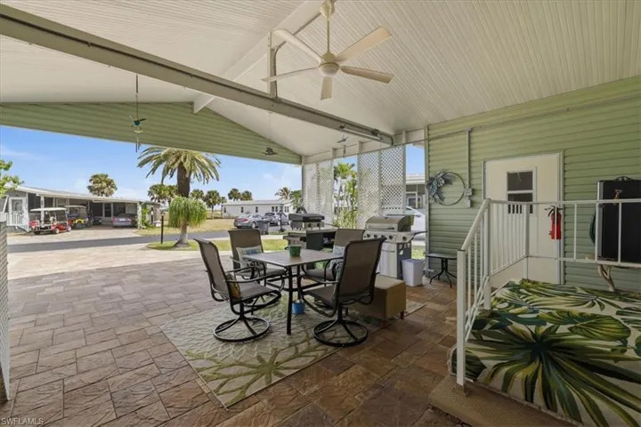 View of patio featuring outdoor dining space, a ceiling fan, and grilling area