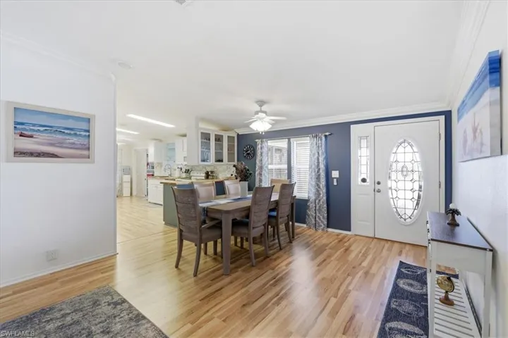 Dining area with crown molding, light wood-style flooring, and ceiling fan