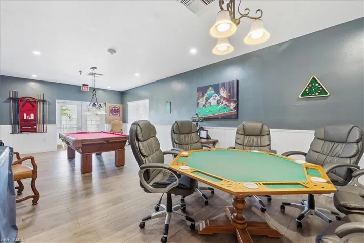 Game room with wainscoting, billiards, and a chandelier