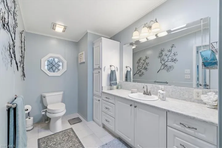 Full bathroom with vanity and crown molding