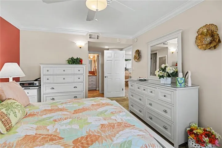 PRIMARY SUITE SHOWING ENTRANCE TO EN-SUITE BATH.  WALK-IN CLOSET.  CROWN MOLDING.
