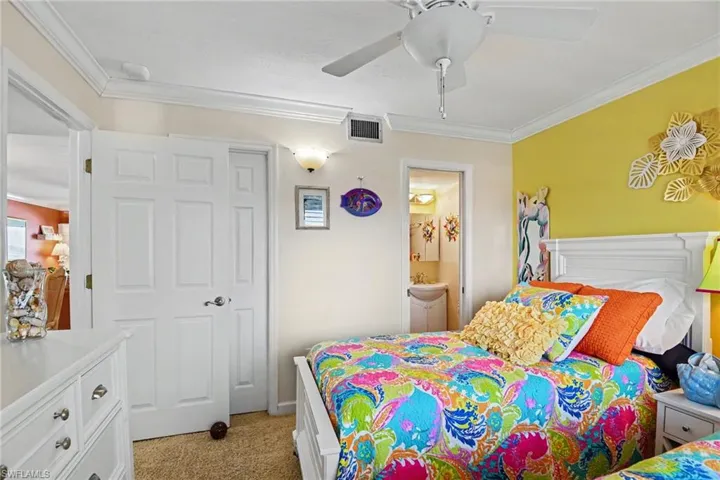 GUEST BEDROOM SUITE.  EN-SUITE BATH SHOWN AT RIGHT.  WALK-IN CLOSET IS SHOWN AT LEFT.  CROWN MOLDING.  UPSCALE FURNISHINGS.