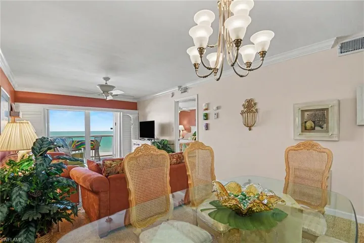 DINING AREA WITH FANTASTIC GULF VIEWS.  ENTRANCE TO PRIMARY SUITE IS SHOWN MIDDLE REAR.  CROWN MOLDING THROUGHOUT UNIT.