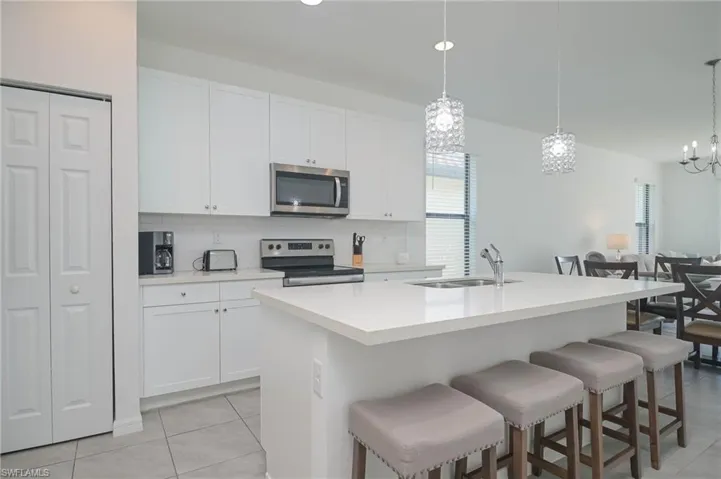 Kitchen featuring appliances with stainless steel finishes, a sink, tasteful backsplash, and plenty of natural light