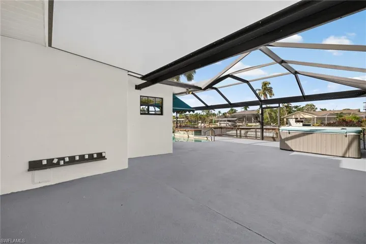 Screened outdoor area featuring a hot tub, a partially covered patio, and a pool