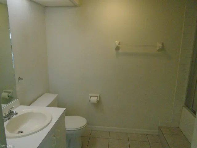 Bathroom featuring tile flooring, vanity, and toilet